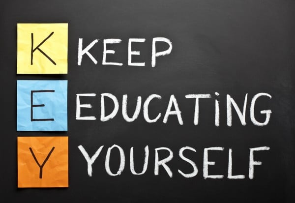 KEY acronym - KEEP EDUCATING YOURSELF. Educational concept with different color sticky notes and white chalk handwriting on a blackboard.